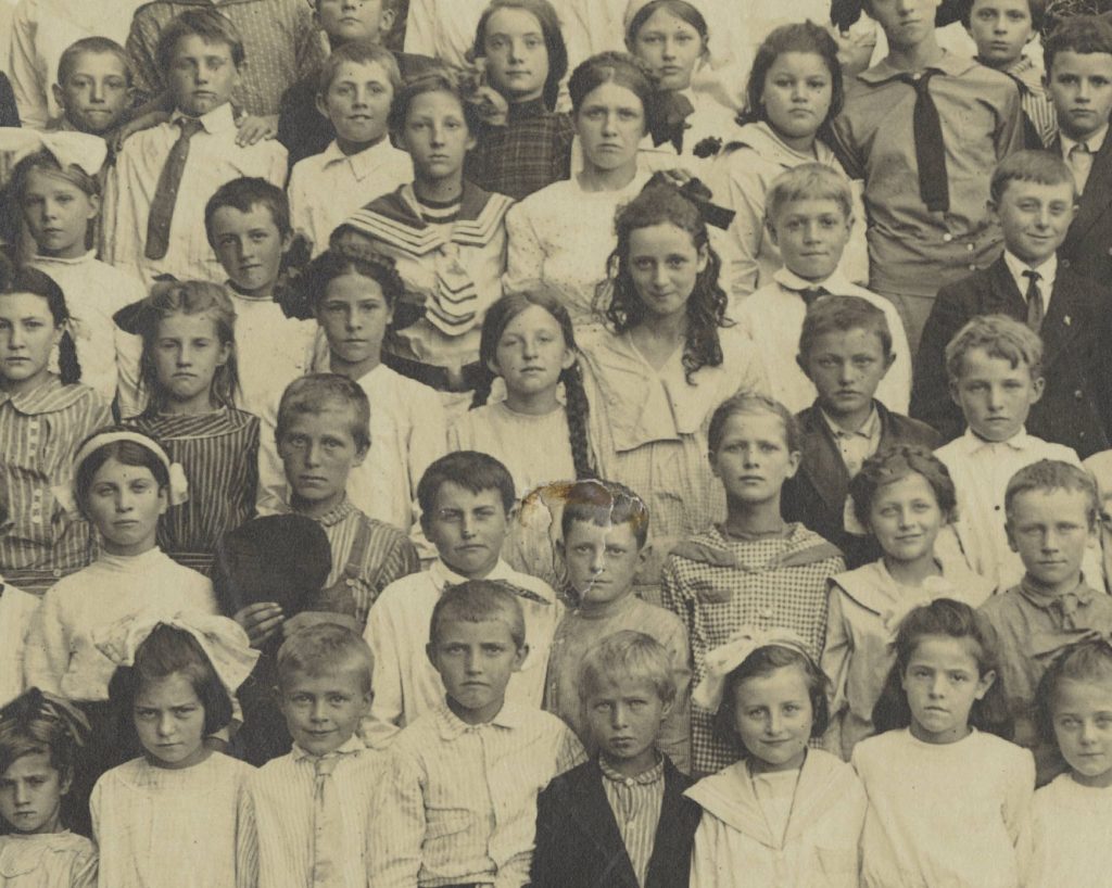Close up of around 30 boys and girls of elementary school age in a group, all facing the camera