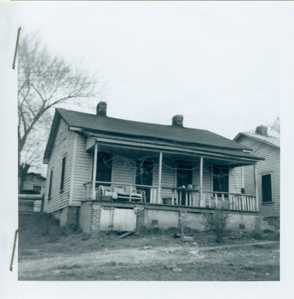 Black and white photograph of a house with a porch