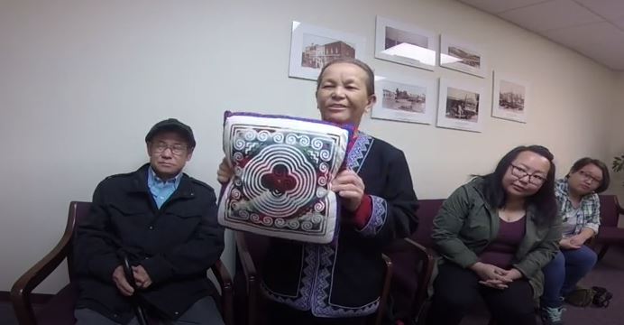 Chia Yang shows a pillow from her home in Vietnam during oral history interview.