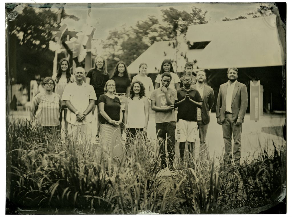 Group portrait of middle schoolers and adults outside in a field