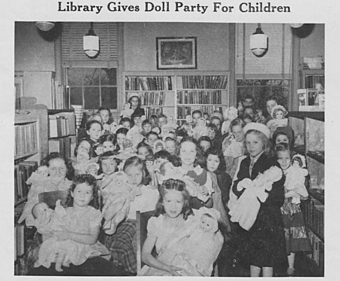 Newspaper clipping of a large group of young girls at a library with their dolls