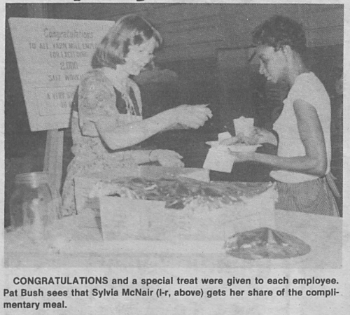 Newspaper clipping of two employees at a workplace event.