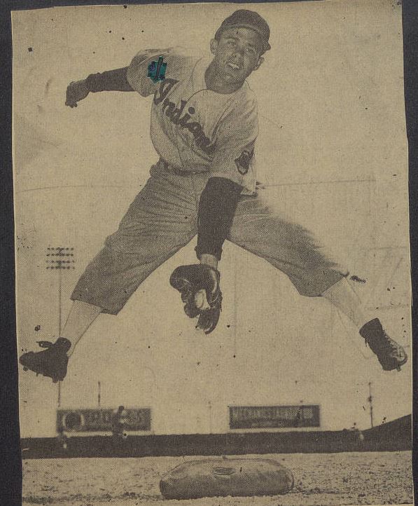 Baseball player jumping and catching a ball between his legs