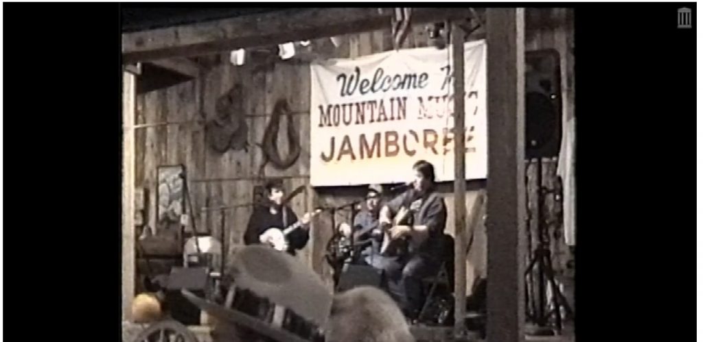 Three adults playing instruments on a stage