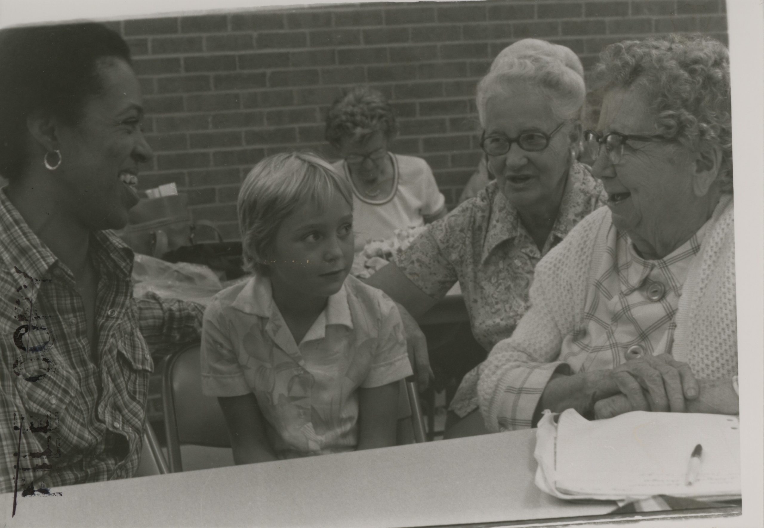 Paula Larke sitting with two older people and one child.