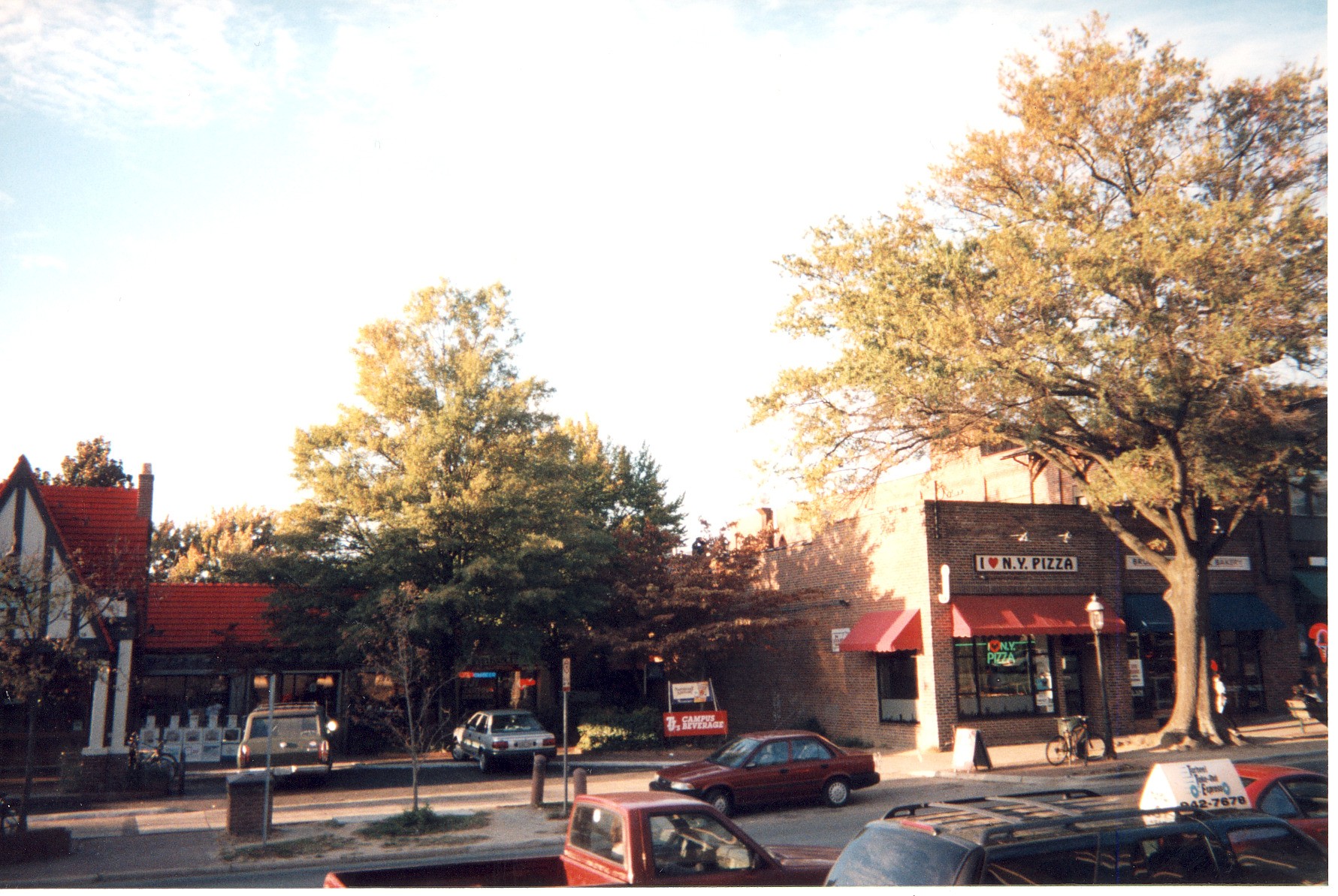 Photo taken on a sunny, fall day from the opposite side of the street of several shops on West Franklin Street, Chapel Hill, North Carolina. I Love N.Y. Pizza and TJ's Campus Beverage are visible.