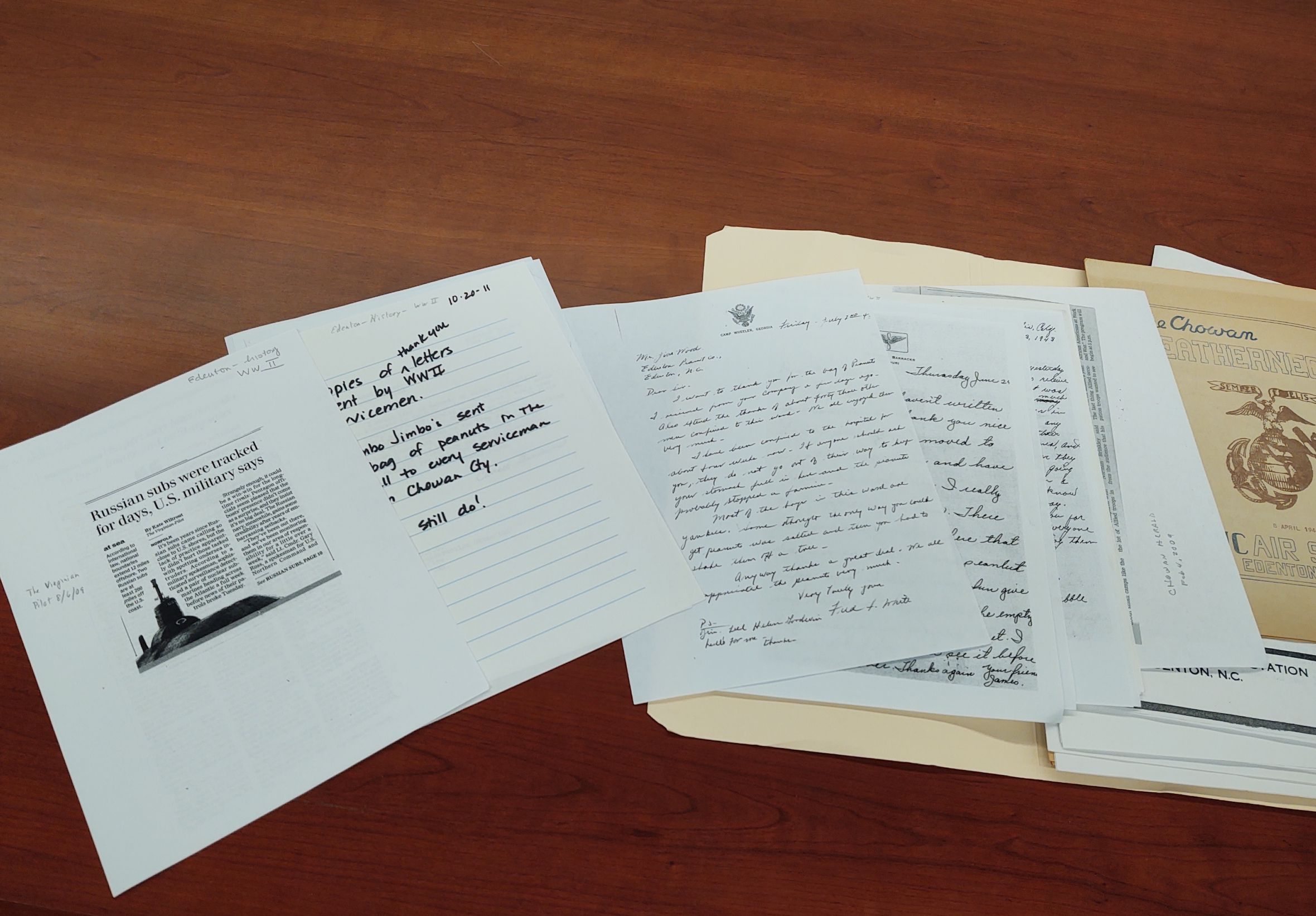 photocopies and papers from a manila folder spread on a wooden table