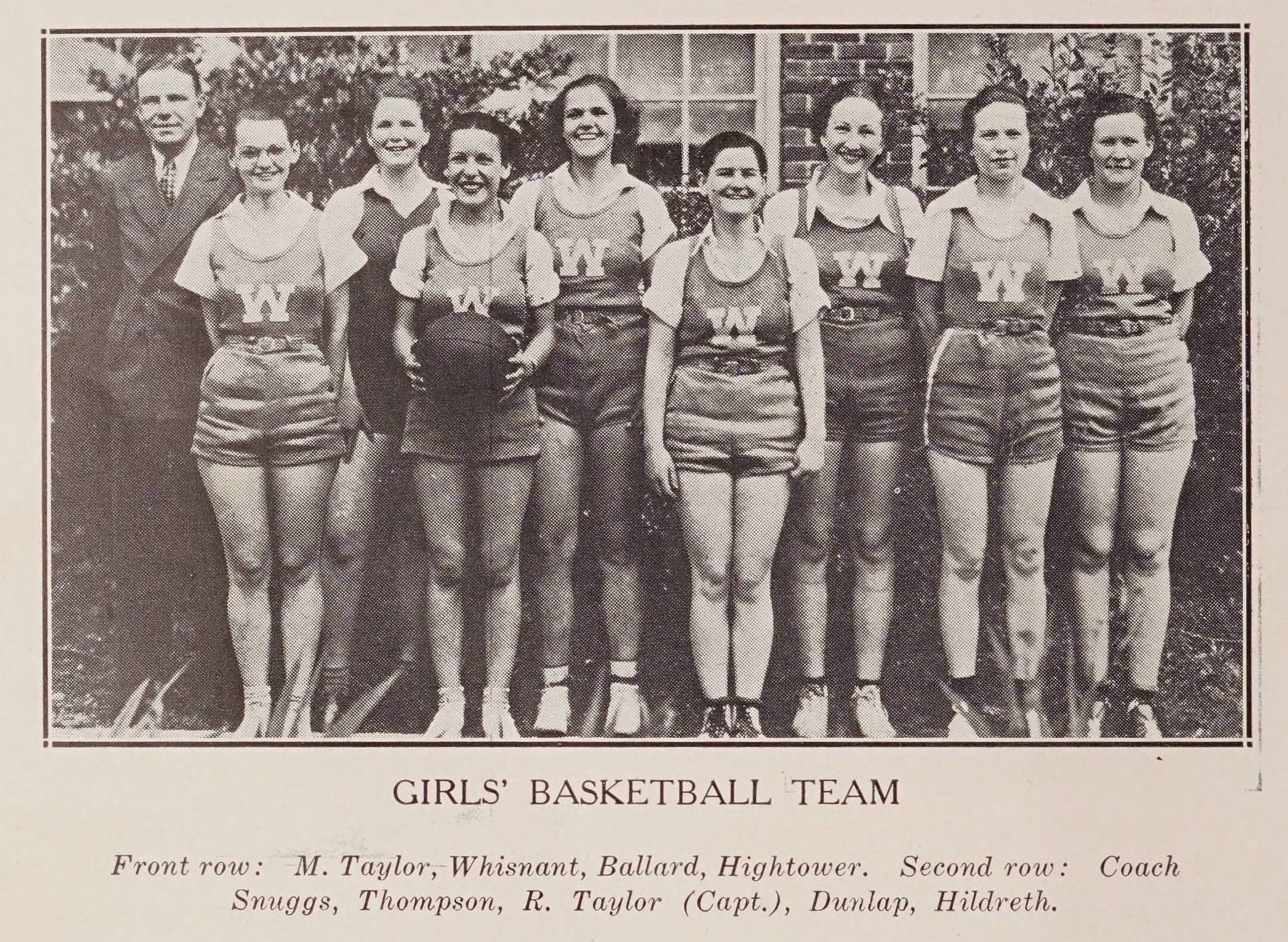 Wadesboro HS 1936 women's basketball team. Eight women lined up in their basketball uniforms. The coach, Coach Snuggs, is on the left.