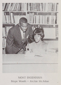 Two students in front of a bookcase