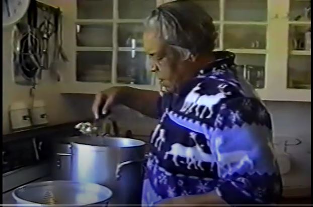 Screenshot of an adult using a spoon with a pot on a stove