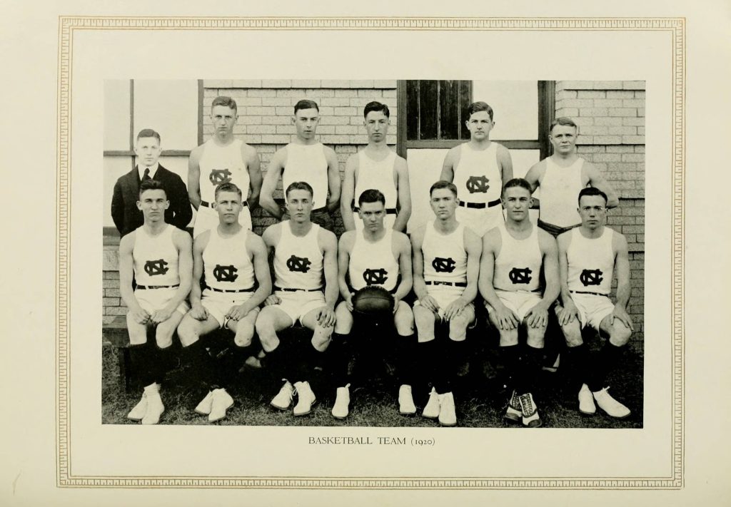 Portrait of white men posed with a basketball all wearing white uniforms with UNC's logo