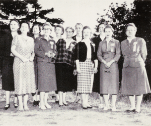 A black-and-white photo of a group of white women standing side by side
