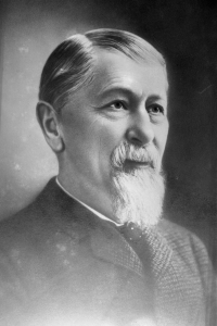A black and white photograph of the bust of a bearded person.