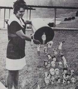 A black-and-white photograph of a student emptying a garbage can. Small photos of other students are pasted on to appear as if they are falling out of the can.
