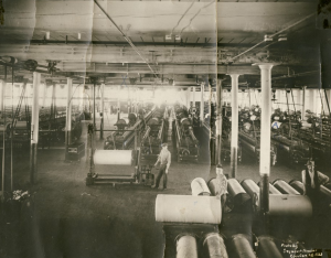 A photograph of beam twisting machinery within a textile mill.