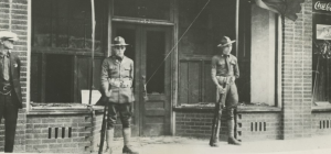 Two guardsmen standing in front of the door to a brick building.