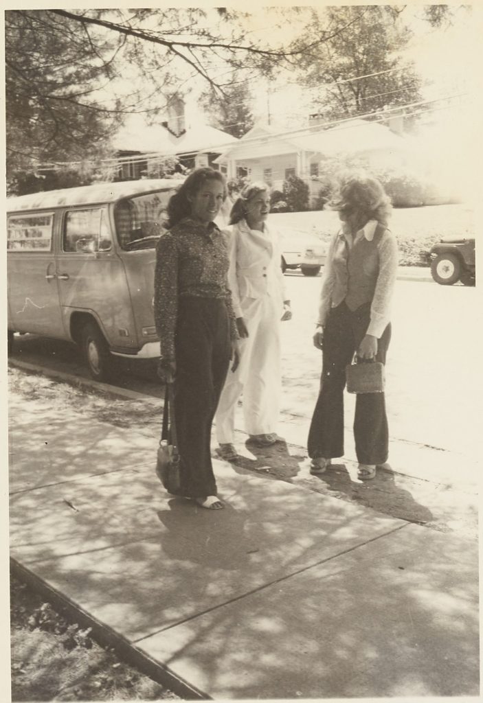 Three individuals dressed in typical 1970s fashion.