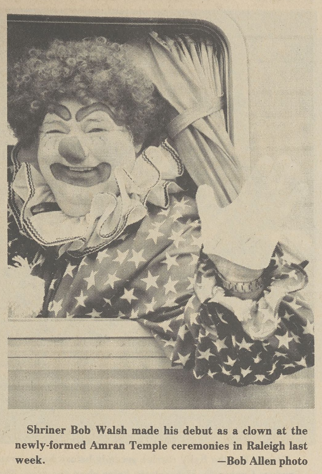 clown with star shirt and curly wig waving out of car window