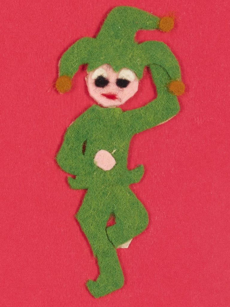 A felted green jester on a red background