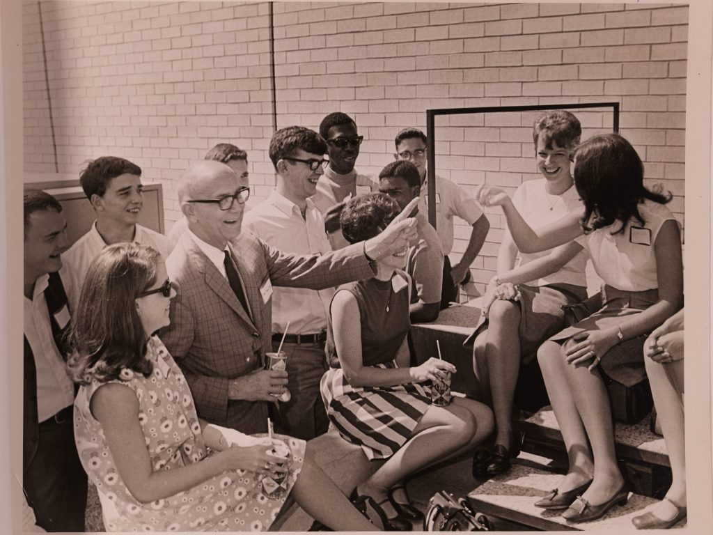 A photo of director Hamilton surrounded by students of the college.