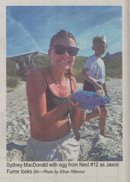 Pine Knoll Shores volunteer with a sea turtle egg