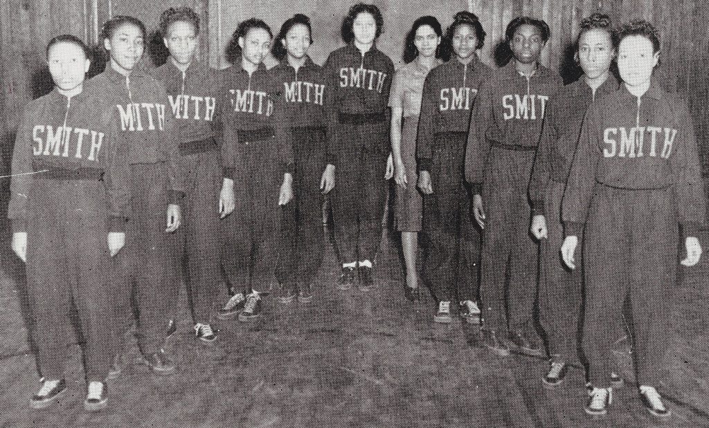 Individuals dressed in uniforms. The top half of the uniform as "SMITH" written on it.