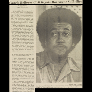 Clippings from paper with headline, excerpt of article, and a photo of Rev. Benjamin Chavis on brown paper with little to no damage. Chavis is pictured with an afro and a short beard. He is wearing a 1970’s style casual collared button up shirt, a chain of a necklace is visible worn outside of his shirt. He is looking off to the side with his eyebrows raised.