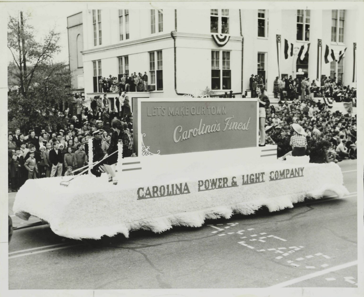 The Carolina Power and Light Company parade float on a street in Burgaw, North Carolina. The float is decorated with the slogan, "Let's Make Our Town Carolina's Finest."