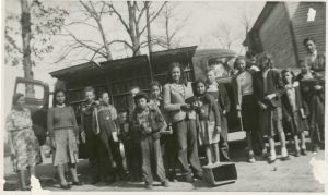 A group of students and teachers from Goins School, a Native American school, stand in front of a visiting bookmobile.