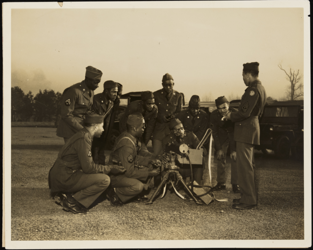 Service members at Morris Field Air Base (Charlotte, N.C.) receiving instruction from First Sergeant Richard A. Stewart about the .30 caliber machine gun that they stand around.