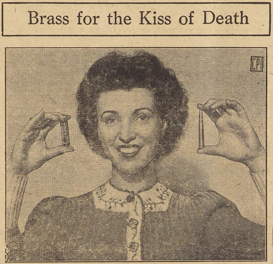 Above the photograph is written: Brass for the Kiss of Death. In the photograph there is a person wearing lipstick comparing a lipstick case and a .303 caliber cartridge. The lipstick case is held up on the left and the cartridge on the right.