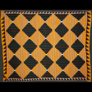 Quilt in a variant pattern of the popular log cabin pattern, the square portion made of vertical stripes of fabric to mimic courthouse steps and has a sawtooth border. Yellow, blue, brown, red and white fabrics are used and the quilt has hand woven lining. Made by Mrs. Mary Holden, mother of Hannah Katherine Holden, of Hillsborough (1878-1929)