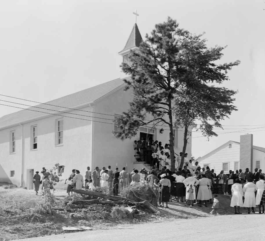 A congregation is seen gathered around the entrance of Union Baptist Church. 