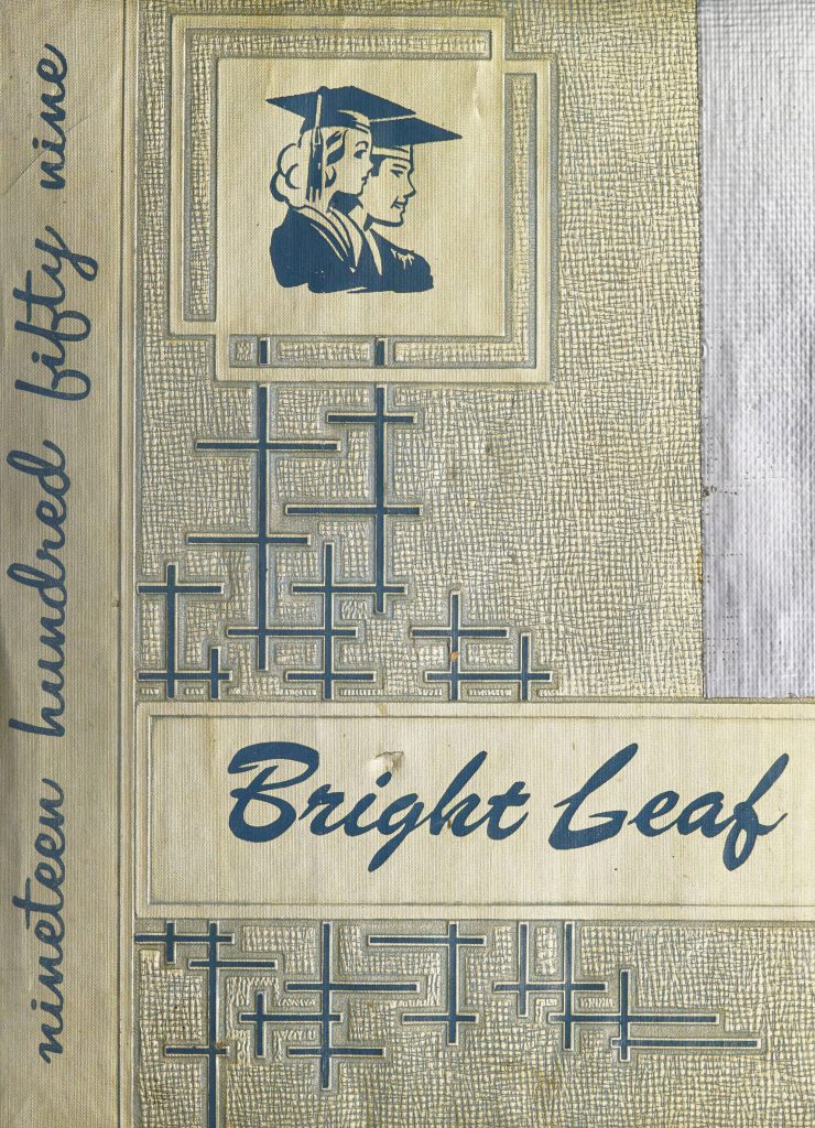 The cover of Bright Leaf [1959]. The light gold cover features the title "Bright Leaf" written in a navy color across the lower half of the cover. Along with the title, the words "nineteen hundred fifty nine" are written up the left side of the cover in navy. In the upper half of the cover, the busts of two graduates are illustrated in navy. 