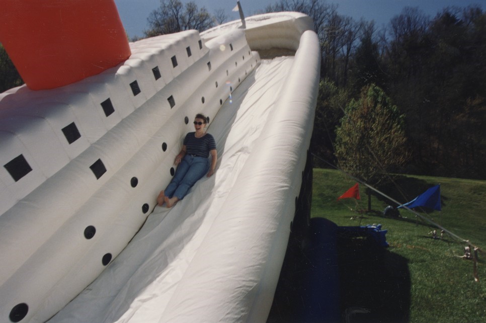 Individual slides down a blow up slide shaped like a sinking Titanic.