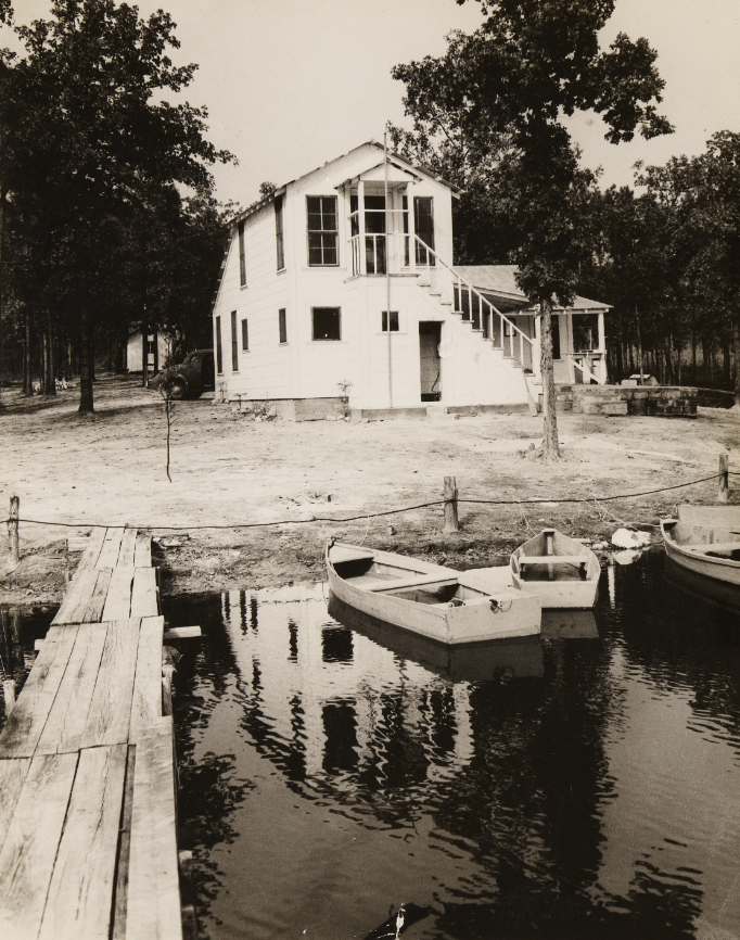 A lake house is shown with the lake in the foreground.