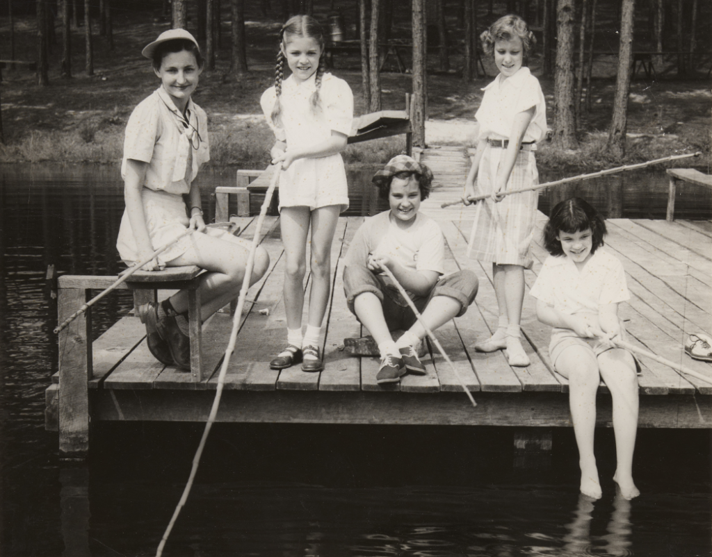 A group of unidentified children fishing from a pier