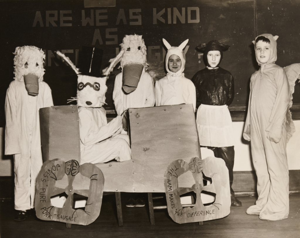 A group of unidentified costumed children in a classroom.