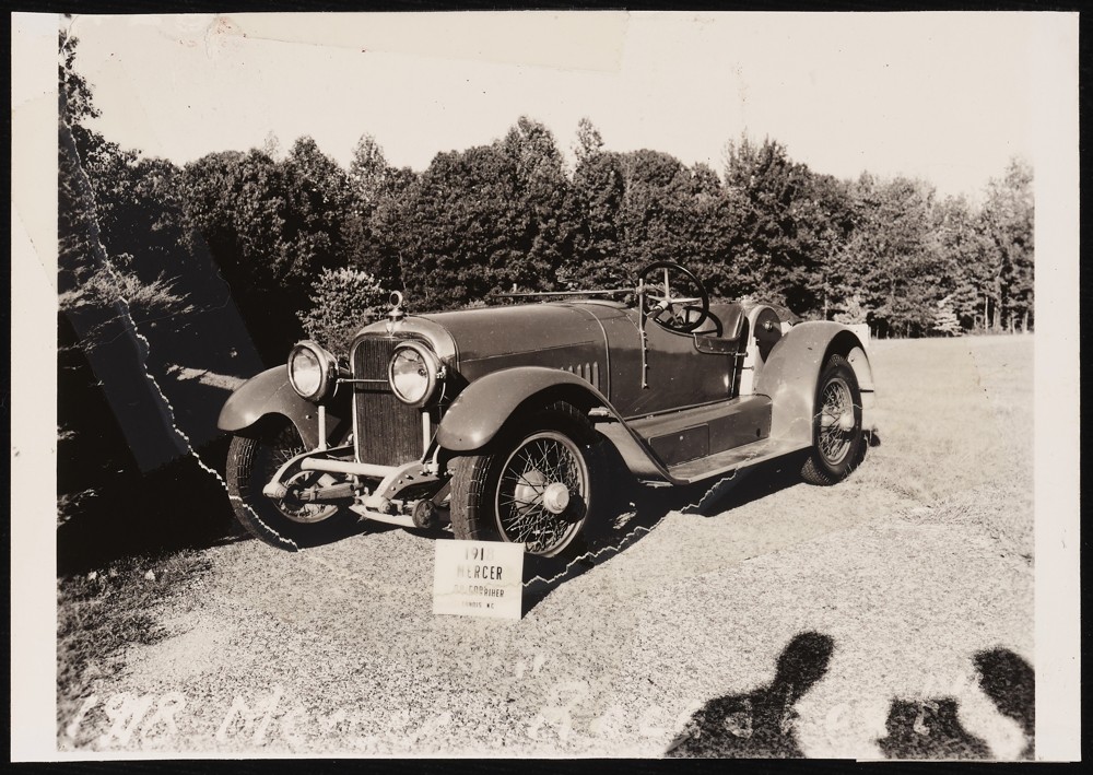 Image of a 1918 Mercer Raceabout with a sign propped against the front tire that reads: O. A. Corriher. Landis, N.C.